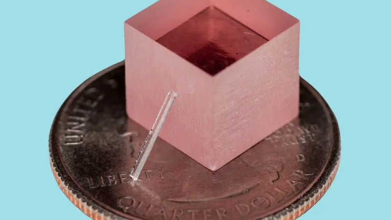 The new laser leans against a block of titanium-sapphire. For scale, both sit atop a quarter. | Yang et al., Nature