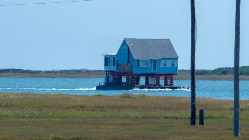 A house, being relocated to higher ground, is transported by barge through Little Egg Inlet along New Jersey’s southeastern coast. Photos by Matthew Drews, Rutgers University