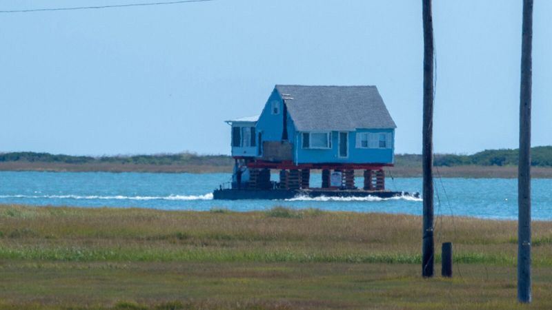 A house, being relocated to higher ground, is transported by barge through Little Egg Inlet along New Jersey’s southeastern coast. Photos by Matthew Drews, Rutgers University