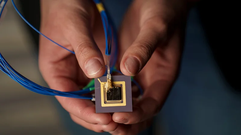 Corsetti’s work focuses on integrated photonics and involves building computer chips that route light instead of electricity, for applications like chip-sized 3D printers and trapped-ion quantum computers. Credit: Jodi Hilton