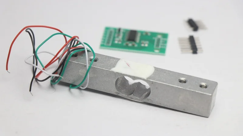 Load Cell Module with Amplifier in the Background with Unsoldered Pins