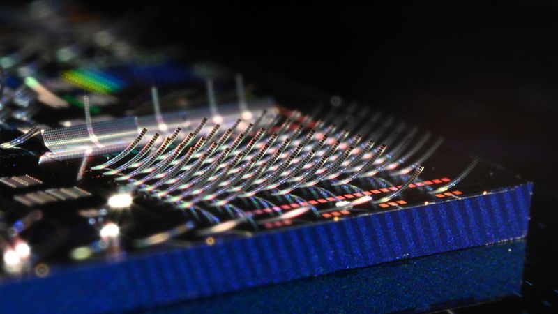 A new class of photonic chips that use light instead of electricity to process data features arrays of microscopic structures that curl upward like tiny, glowing ski jumps. Researchers can precisely control how light is emitted from thousands of these structures simultaneously. Image: Courtesy of the researchers