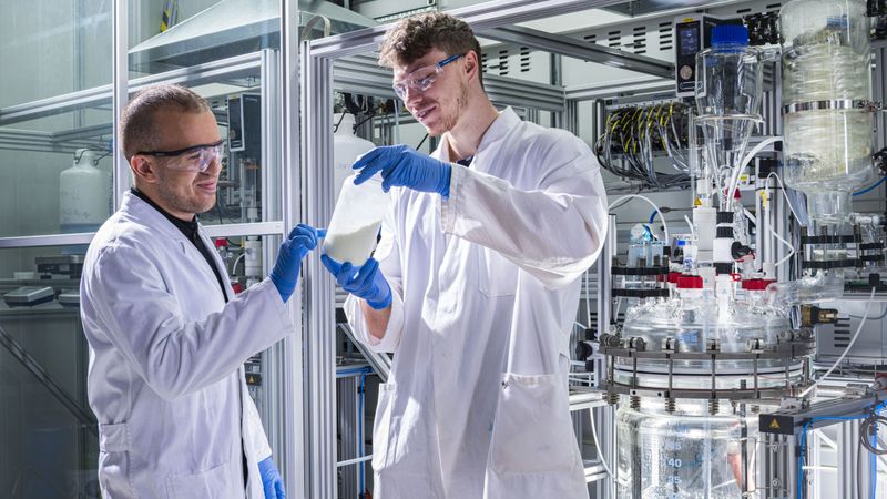 Litona founder Sebastian Büchele shows a bottle of the energy storage material Preußisch Weiß for sodium-ion batteries. (Photo: Markus Breig, KIT)