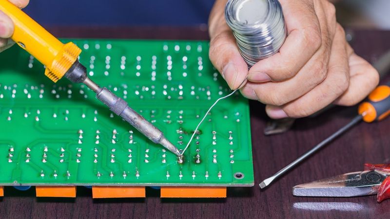 Soldering on circuit board with soldering iron and solder in board repairing