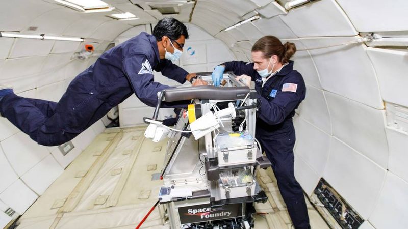 Space Foundry CEO and co-founder Dr. Ram Prasad Gandhiraman (left) and CTO and co-founder Dr. Dennis Nordlund operate the company’s plasma jet printing of electronics experiment in microgravity on a parabolic flight in December 2021 Credits: Zero Gravity Corporation/Steve Boxall