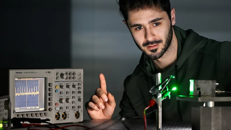 Researcher Riccardo Ollearo shows how the photodiode (right) picks up the signal from his finger, allowing him to see how fast his heart is beating on the screen (left). (Photo: Bart van Overbeeke)