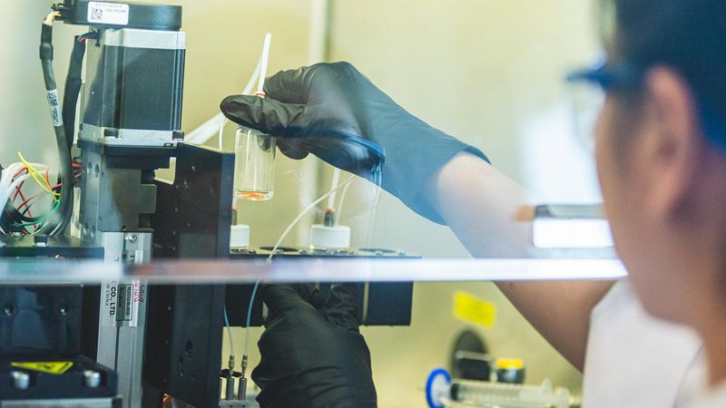 Miji Yeo, a postdoctoral researcher at Penn State, checks the bioink cartridges on a 3D printer developed to intraoperatively print layers of skin. Credit: Michelle Bixby/Penn State. All Rights Reserved.