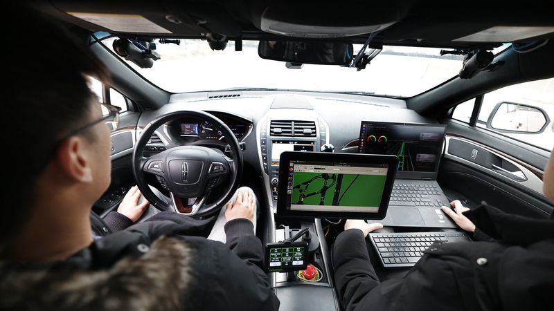 Xintao Yan and Haojie Zhu, both civil engineering PhD students, prepare to take one of the autonomous vehicles for a test run at Mcity. Photo: Brenda Ahearn/Michigan Engineering