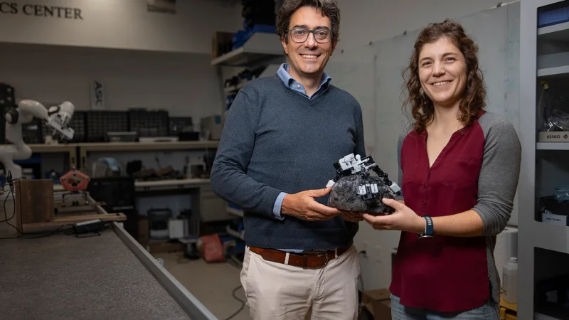 Associate Professor Marco Pavone and PhD student Stephanie Newdick holding their ReachBot prototype. | Photo courtesy of Andrew Brodhead