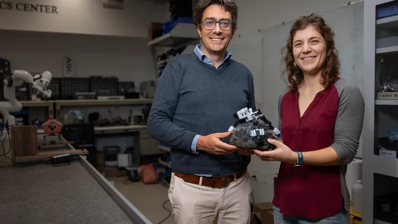 Associate Professor Marco Pavone and PhD student Stephanie Newdick holding their ReachBot prototype. | Photo courtesy of Andrew Brodhead