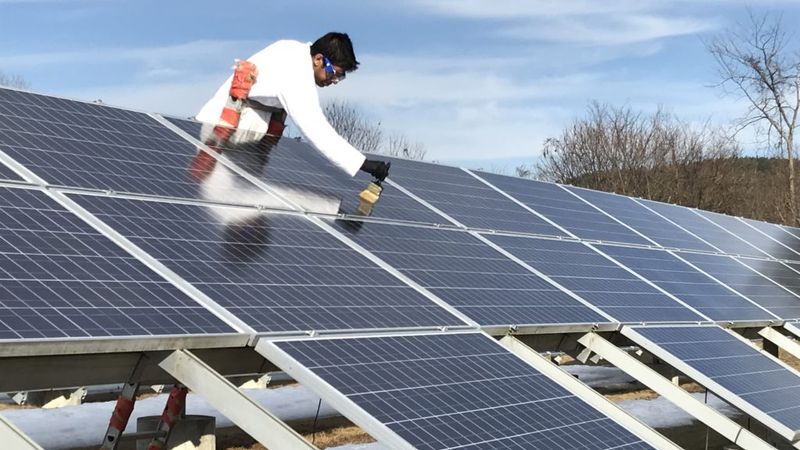 U-M materials science and engineering graduate researcher Abhishek Dhyani applies ice-and-snow-repellent coating to a solar panel in Fairbanks, Alaska. Credit: Laurie Burnham, Sandia National Laboratory