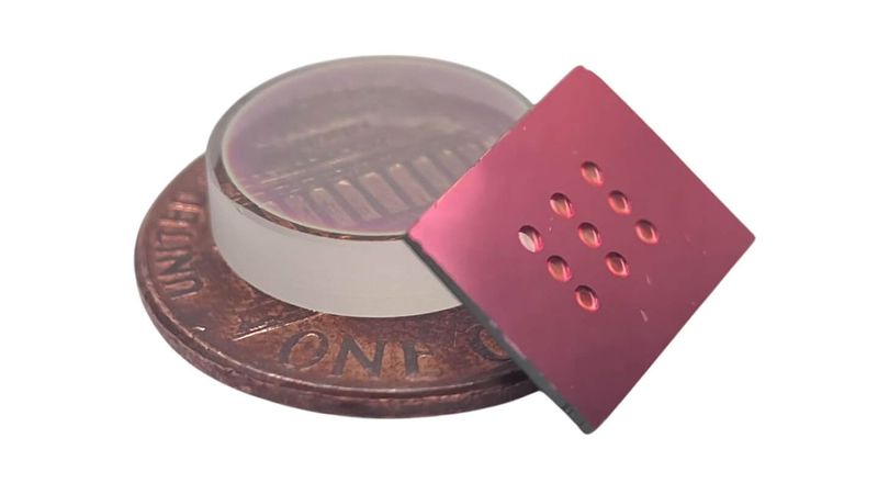 A fabricated micromirror array next to a penny, compared with a half-inch diameter commercial mirror.