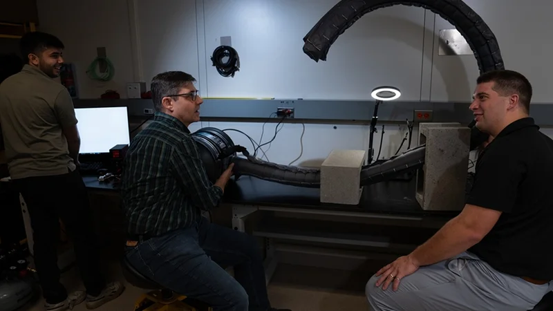 Left to right: Summer research intern Ankush Dhawan and Lincoln Laboratory staff members Chad Council and Nathaniel Hanson test a vine robot in a laboratory setting. Photo: Glen Cooper